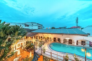 Un hôtel doté d’une piscine, d’un espace extérieur aménagé et offrant une vue sur les bâtiments environnants.