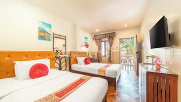 Quarto de hotel com duas camas, uma mesa de escritório, televisão e banheiro visível por uma porta aberta.