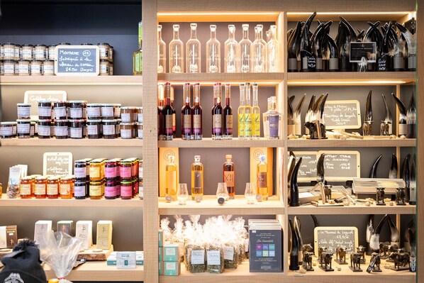 A well-organized store with shelves of various products including jars, bottles, and decorative items. - Logis Hôtel l'Aubrac (Laguiole)