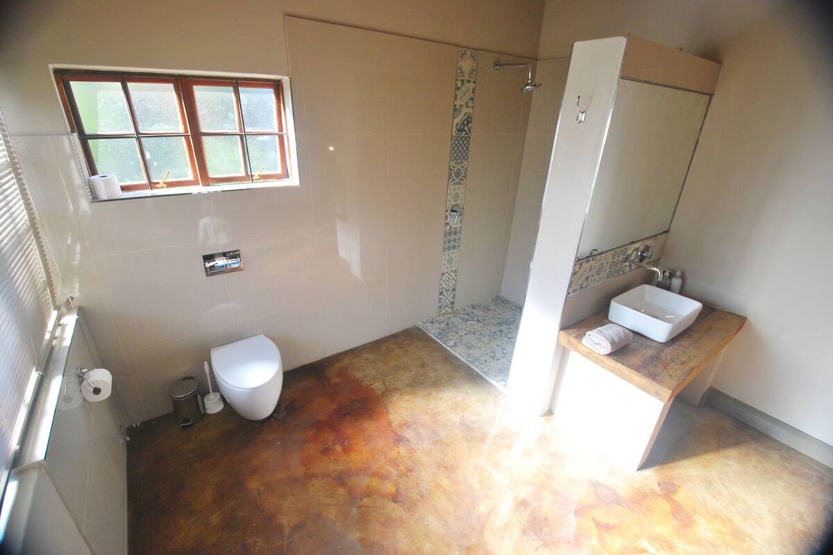 Ein Badezimmer mit Toilette, Waschbecken, Dusche und Fenster.