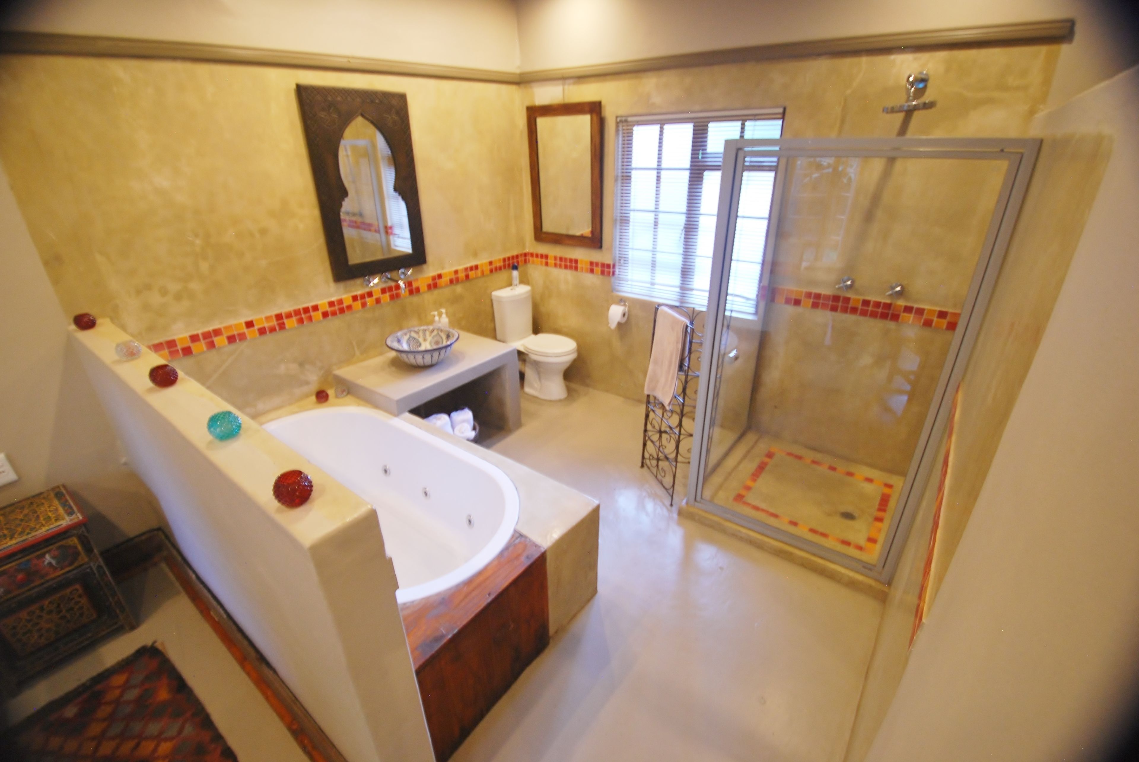 A bathroom with a bathtub, toilet, and glass shower enclosure.