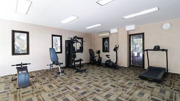 Un gimnasio con equipo de ejercicio, una cinta de correr y una bicicleta estática.
