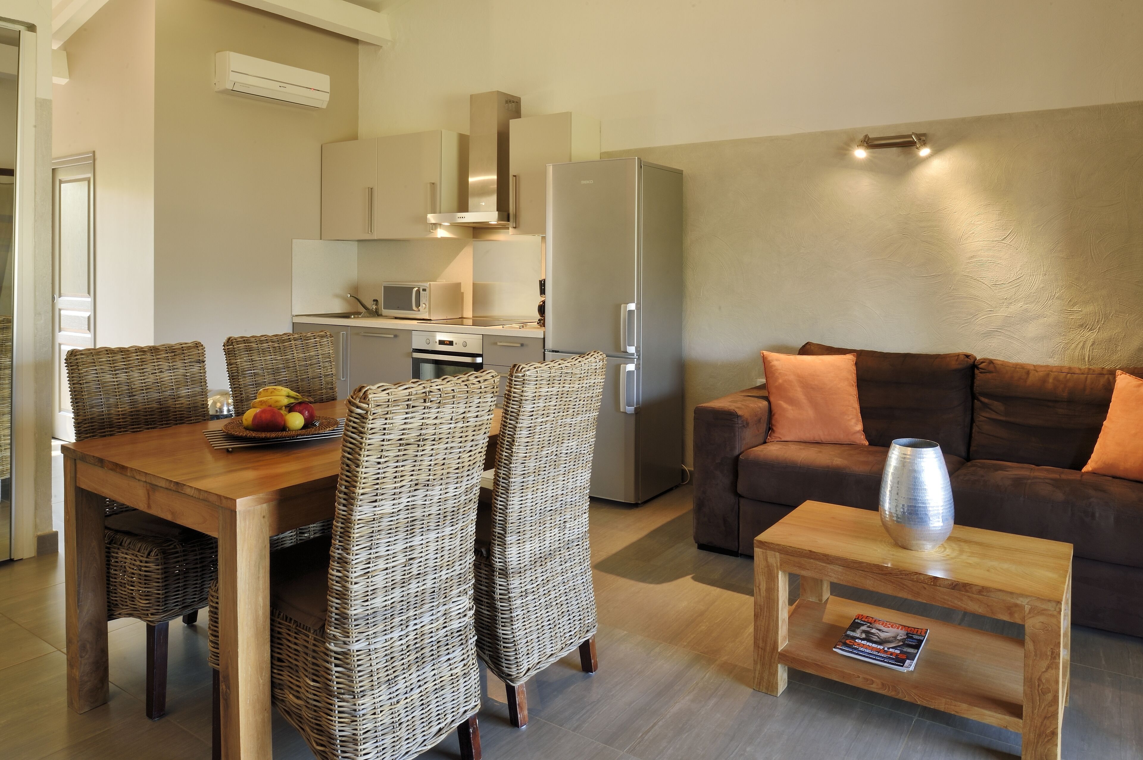 A modern kitchen with a dining area, a sofa, and a coffee table.