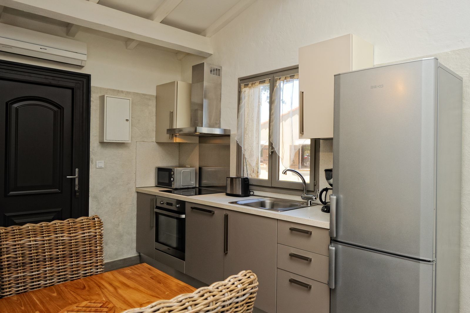 Une cuisine compacte équipée d’un réfrigérateur, d’un four à micro-ondes, d’une cuisinière et d’un évier.