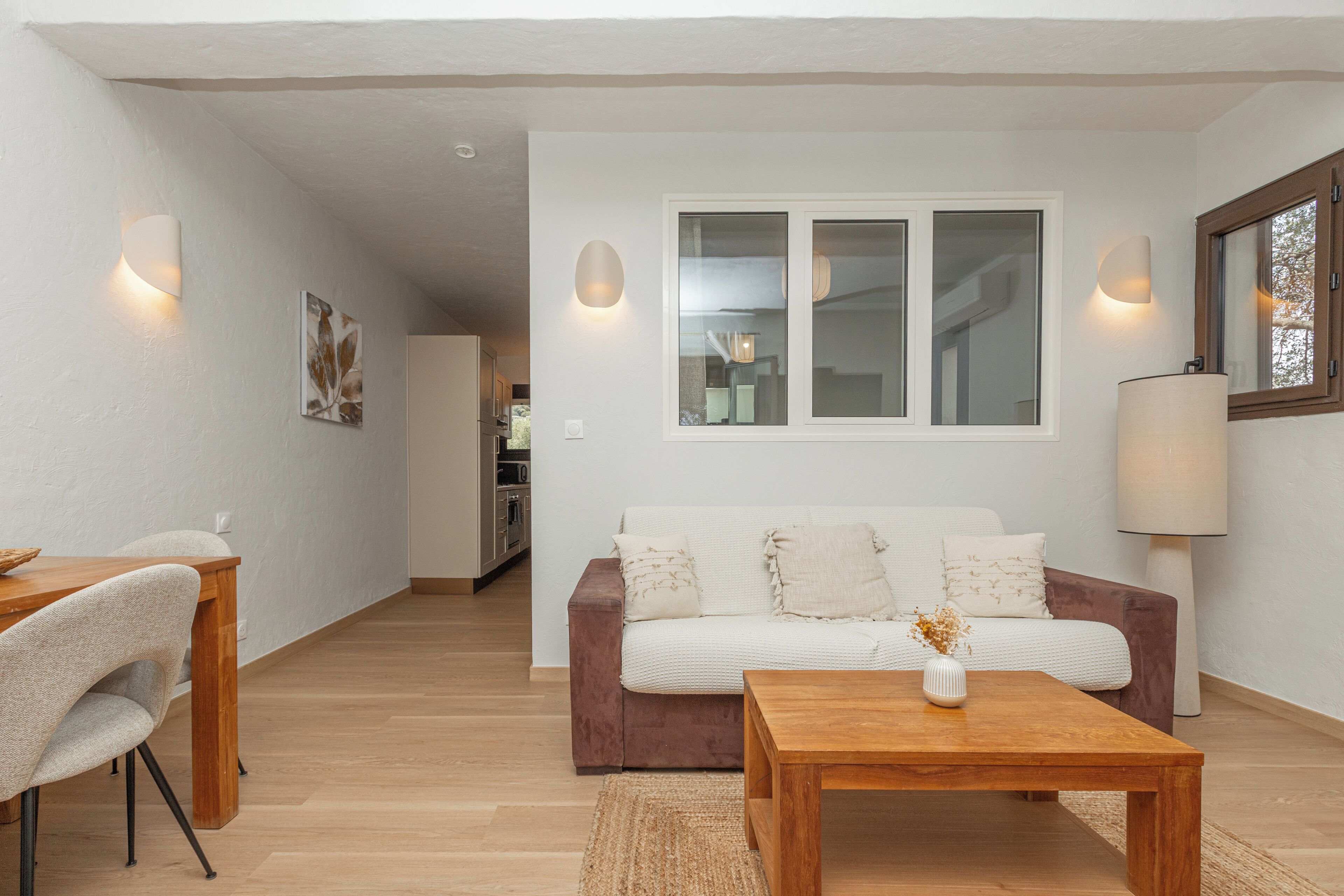 A modern living room with a sofa, coffee table, and dining area.