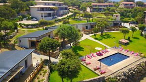 Un quartier résidentiel comprenant plusieurs maisons, une piscine et une pelouse bien entretenue.