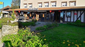 Un hôtel doté d’une terrasse, d’un espace extérieur aménagé et d’un jardin.