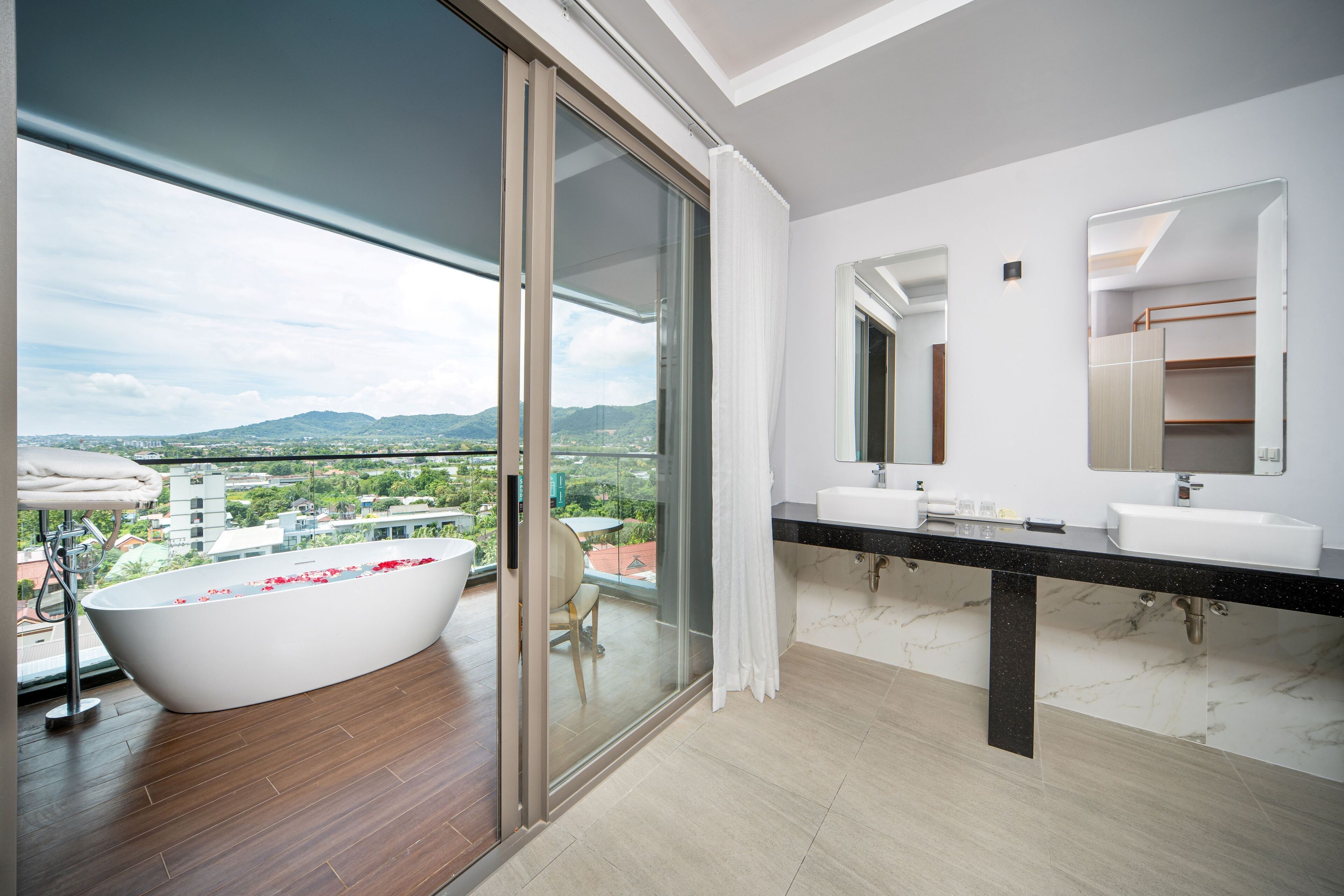 Un baño moderno con una bañera grande, dos lavabos y un espejo amplio.