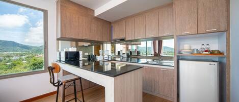 A modern kitchen with wooden cabinets, a central island, and a built-in refrigerator.