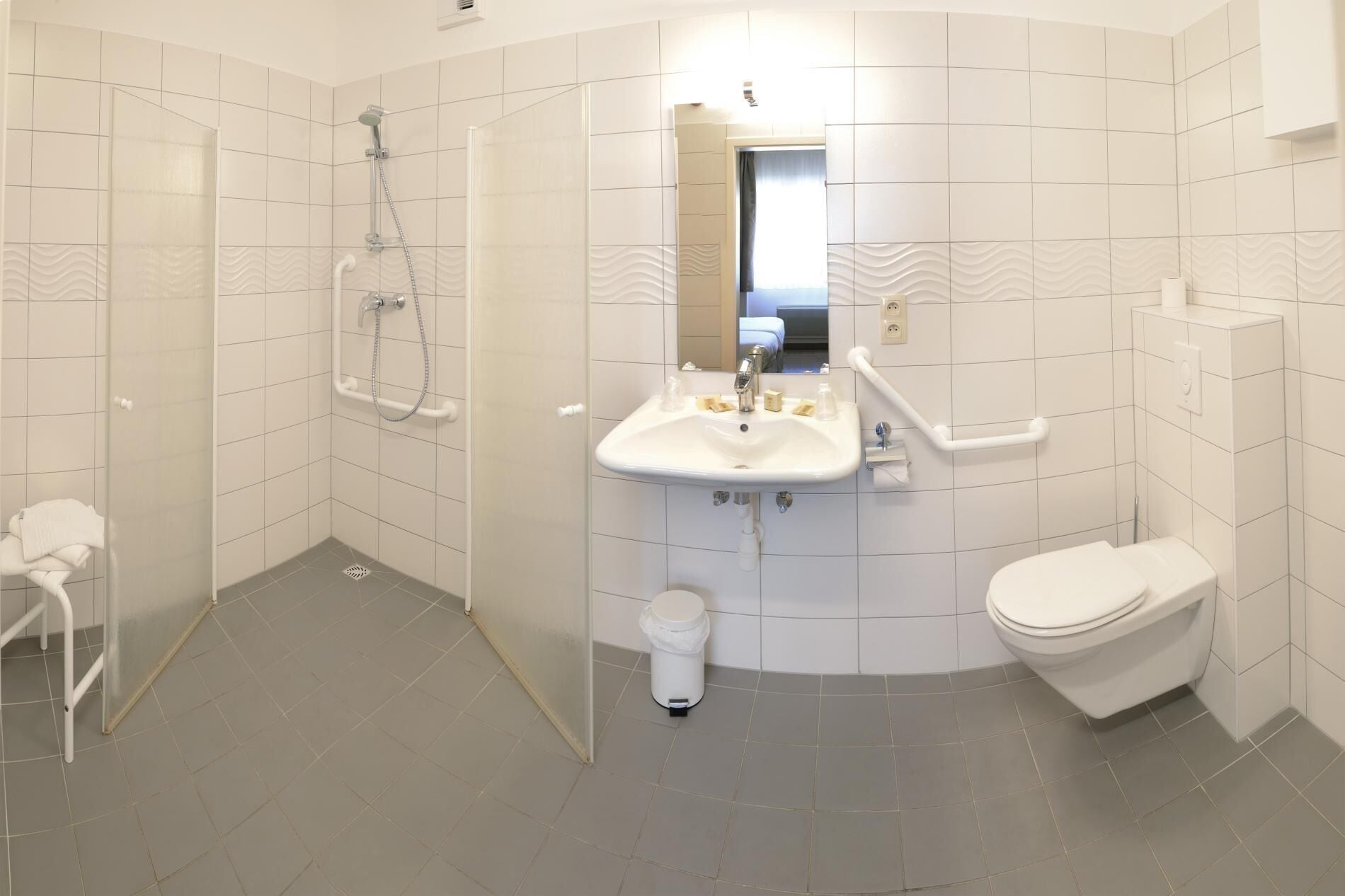 Ett modernt badrum med dusch, toalett och handfat.