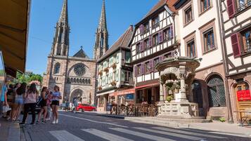 A historic street with a church, a hotel, and traditional half-timbered buildings.
