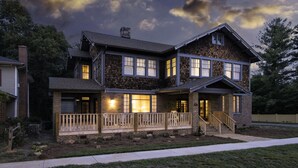 A two-story house with a front porch, a staircase leading to the entrance, and a brick exterior. - Morgan and Wells B&B (Shelby)