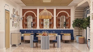 A spacious dining area with a long bench, round tables, and striped chairs. - Calido Sol Hotel - All inclusive (Alanya)