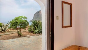 Un patio de piedra con vistas al océano y a la montaña.