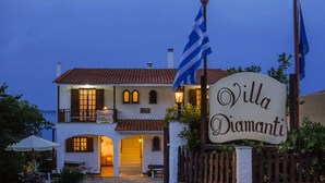Villa Diamanti, un edificio de dos pisos con un letrero, una bandera y un farol.