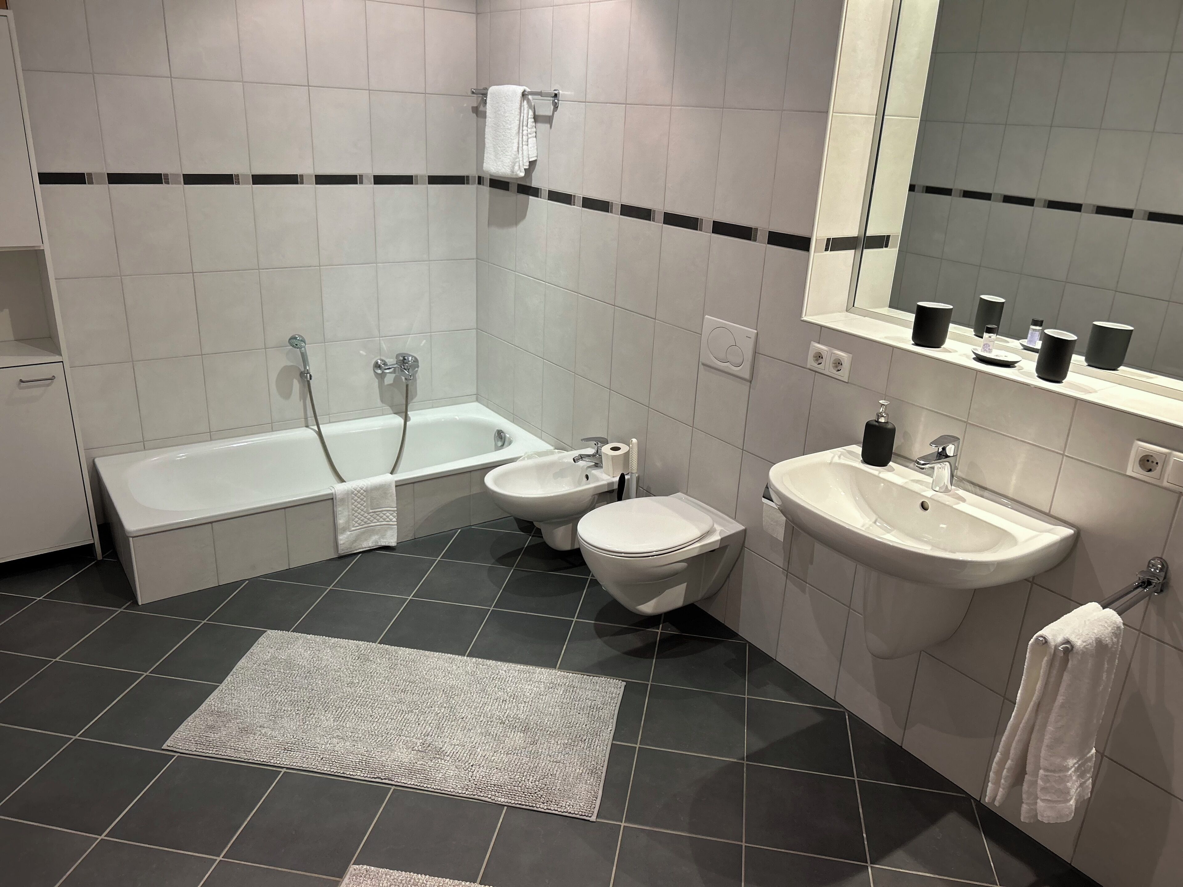 A modern bathroom with a bathtub, toilet, and sink.
