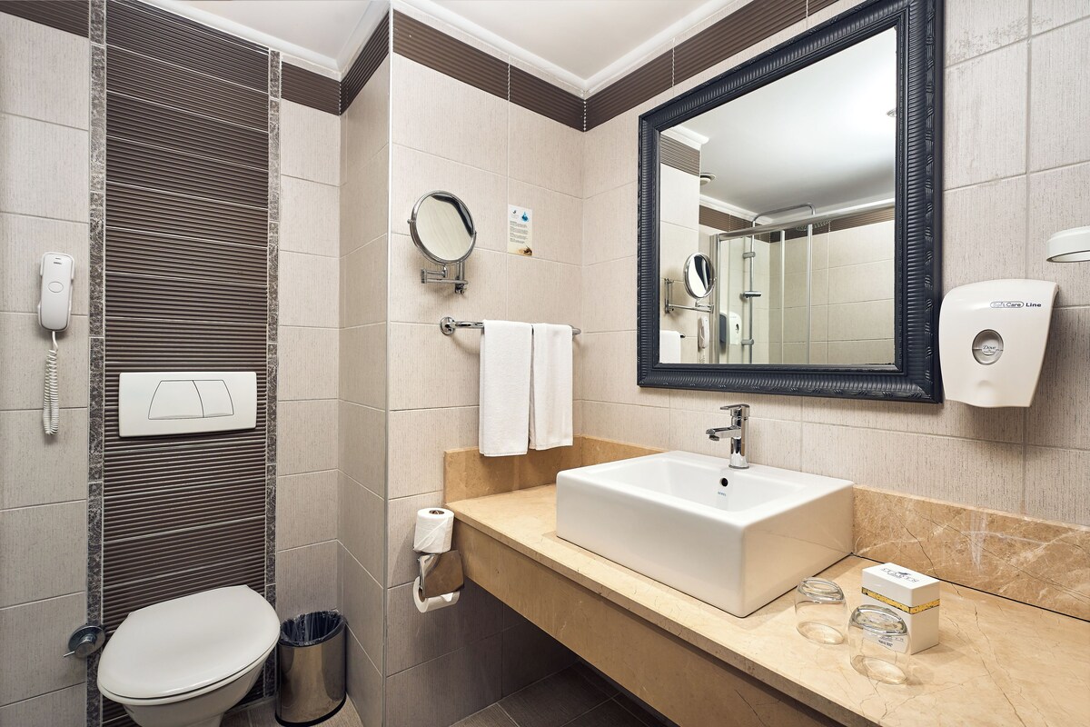 A modern bathroom with a toilet, sink, and mirror.