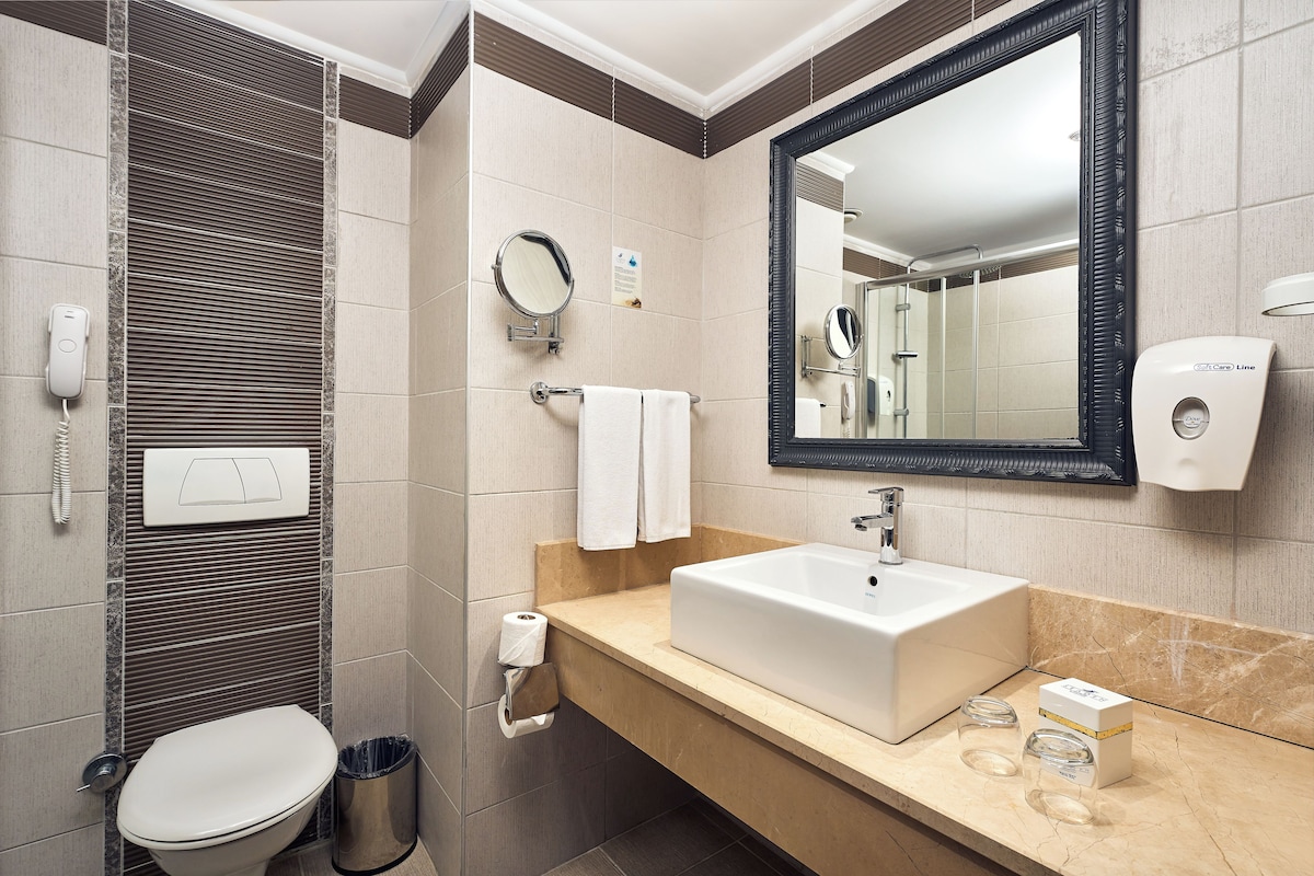 A modern bathroom with a toilet, sink, and mirror.