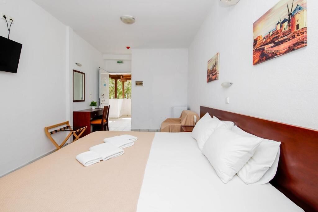 Een hotelkamer met een bed, een bureau, een stoel en een televisie.