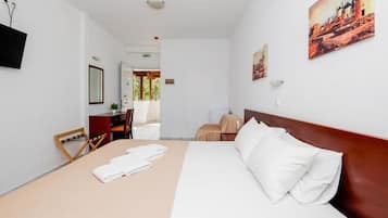Een hotelkamer met een bed, een bureau, een stoel en een televisie.