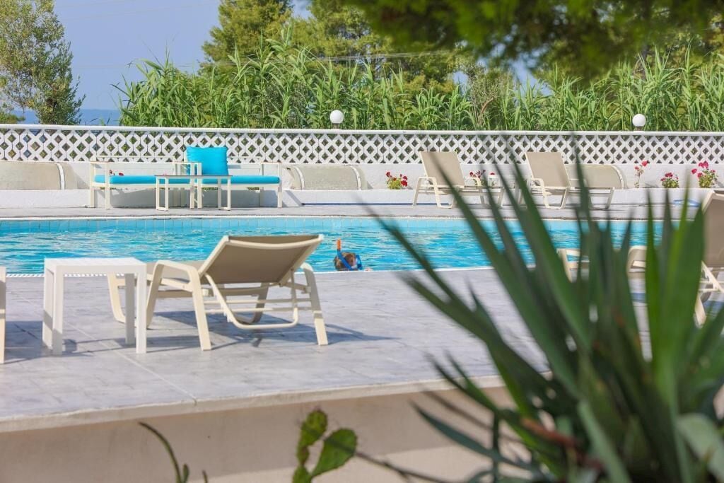 A pool area with lounge chairs and a small pool.