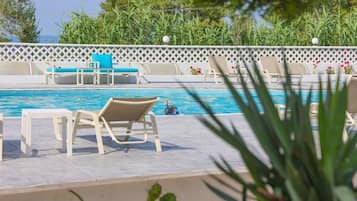 A pool area with lounge chairs and a small pool.