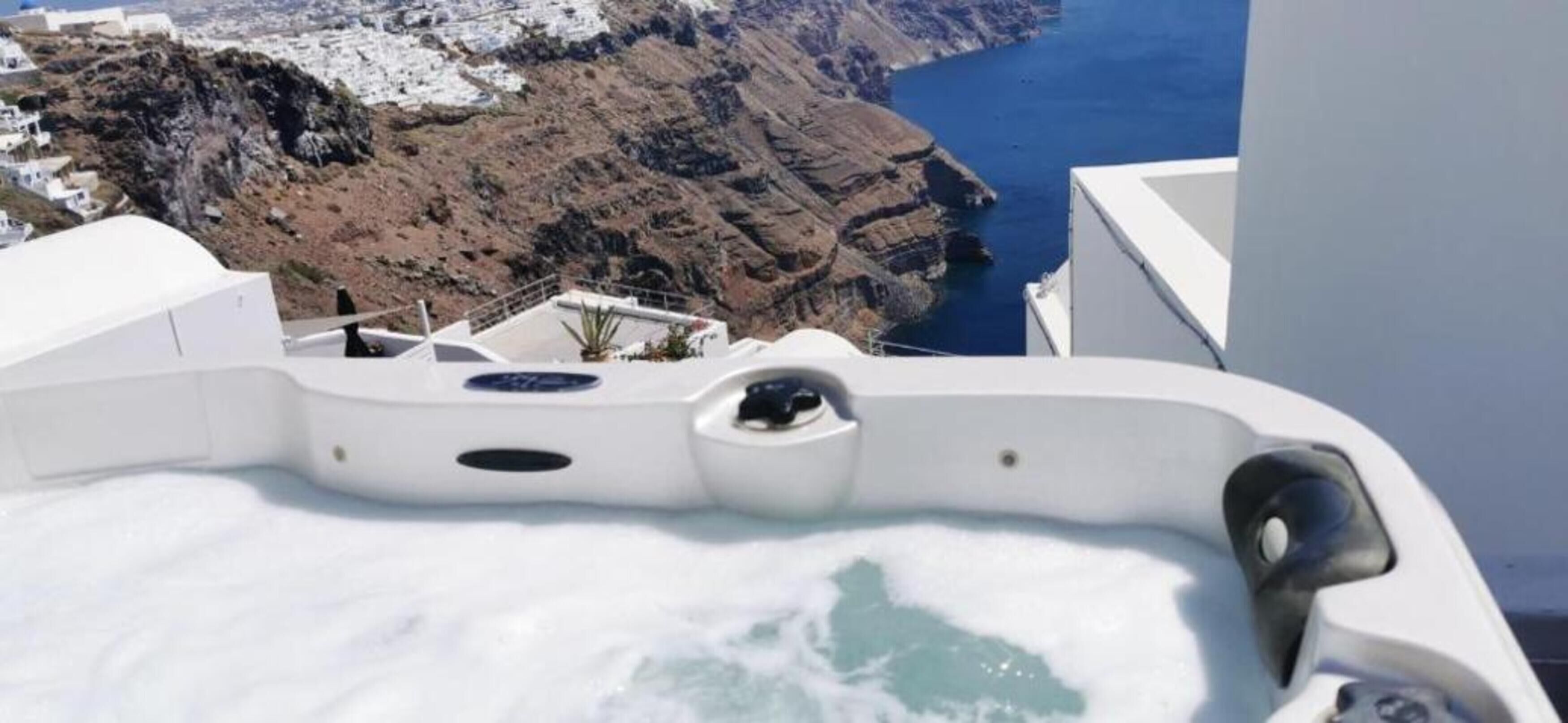 A hot tub with a view of a coastal landscape.
