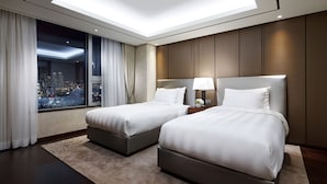 A hotel room with two beds, a skylight, a city view, and a nightstand with a lamp. - LOTTE CITY HOTEL ULSAN (Ulsan)