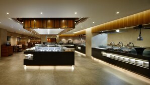 A modern hotel lobby with a central reception desk, seating area, and a buffet setup. - LOTTE CITY HOTEL ULSAN (Ulsan)