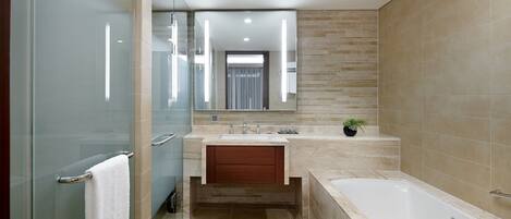 Un bagno moderno con cabina doccia in vetro, mobile bagno in legno, vasca da bagno ampia e specchio sopra il lavabo.