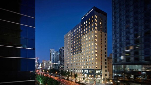 A high-rise hotel with multiple floors, a prominent sign at the top, and a busy street with lights in the foreground. - LOTTE CITY HOTEL ULSAN (Ulsan)