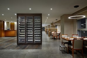Eine moderne Hotelhalle mit Weinkeller, Essbereich und Rezeption.