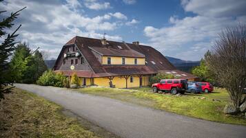 Traditional chalet-style building with a sloped roof and chimney, set amidst a serene rural landscape.