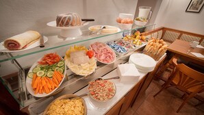 A buffet with various food items including sandwiches, fruits, and snacks. - Penzion Farma U Mauritzů (Stozec)