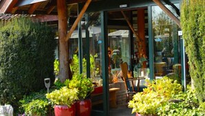 A building with a sign reading "de Panoven" and a welcoming entrance with potted plants and a wooden structure. - Buitengoed de Panoven (Zevenaar)