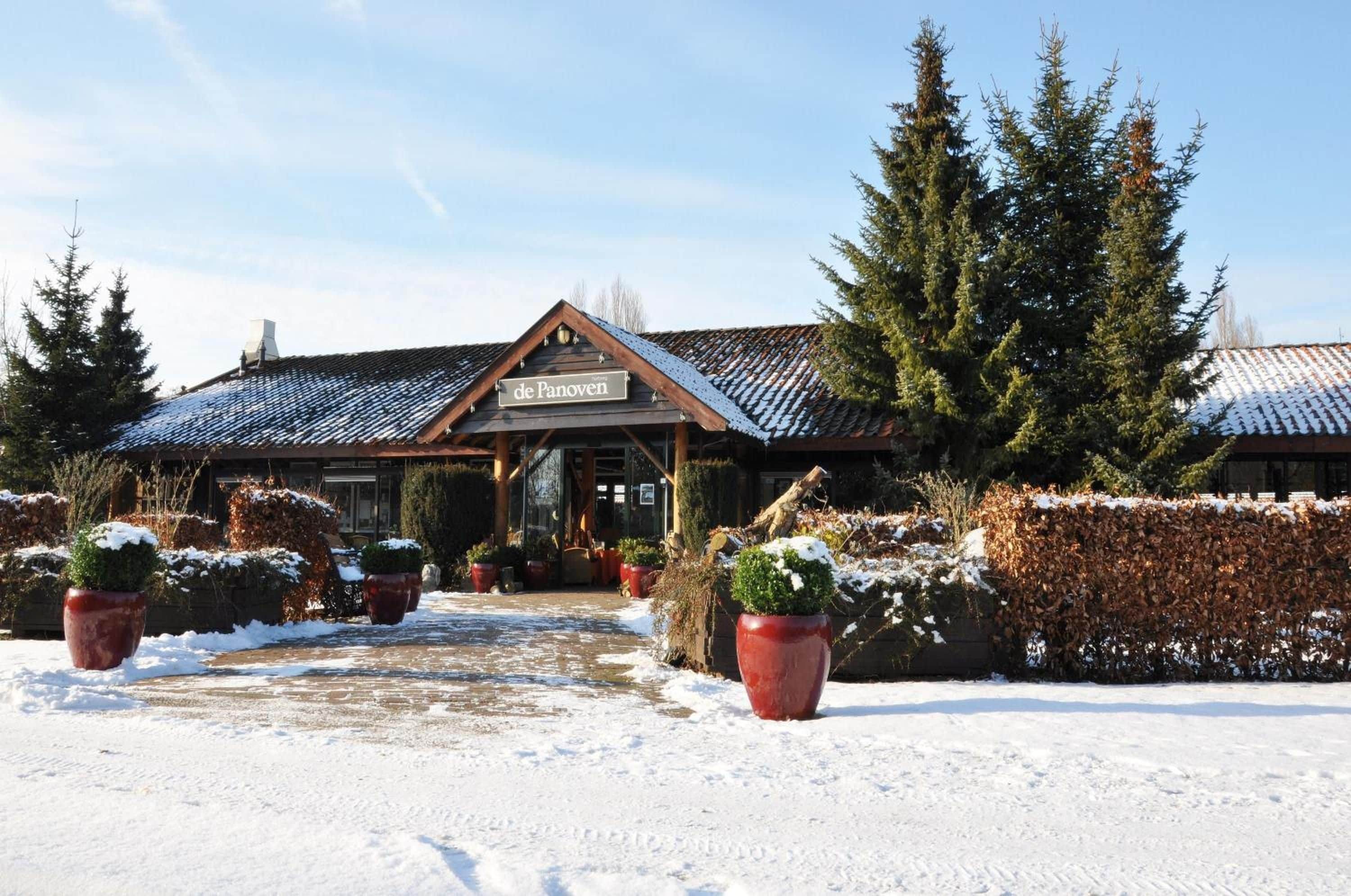 Un edificio con un letrero que dice 'de Panoven' y una entrada cubierta de nieve.
