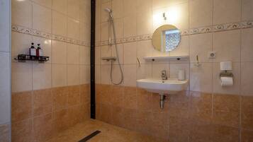 Une salle de bain avec une douche, un lavabo et des toilettes.