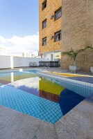 Una piscina al aire libre, sillones reclinables de piscina