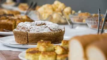 A table with various baked goods, including a cake and pastries.