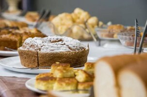 Uma mesa com diversos doces, incluindo bolo e pastelaria.