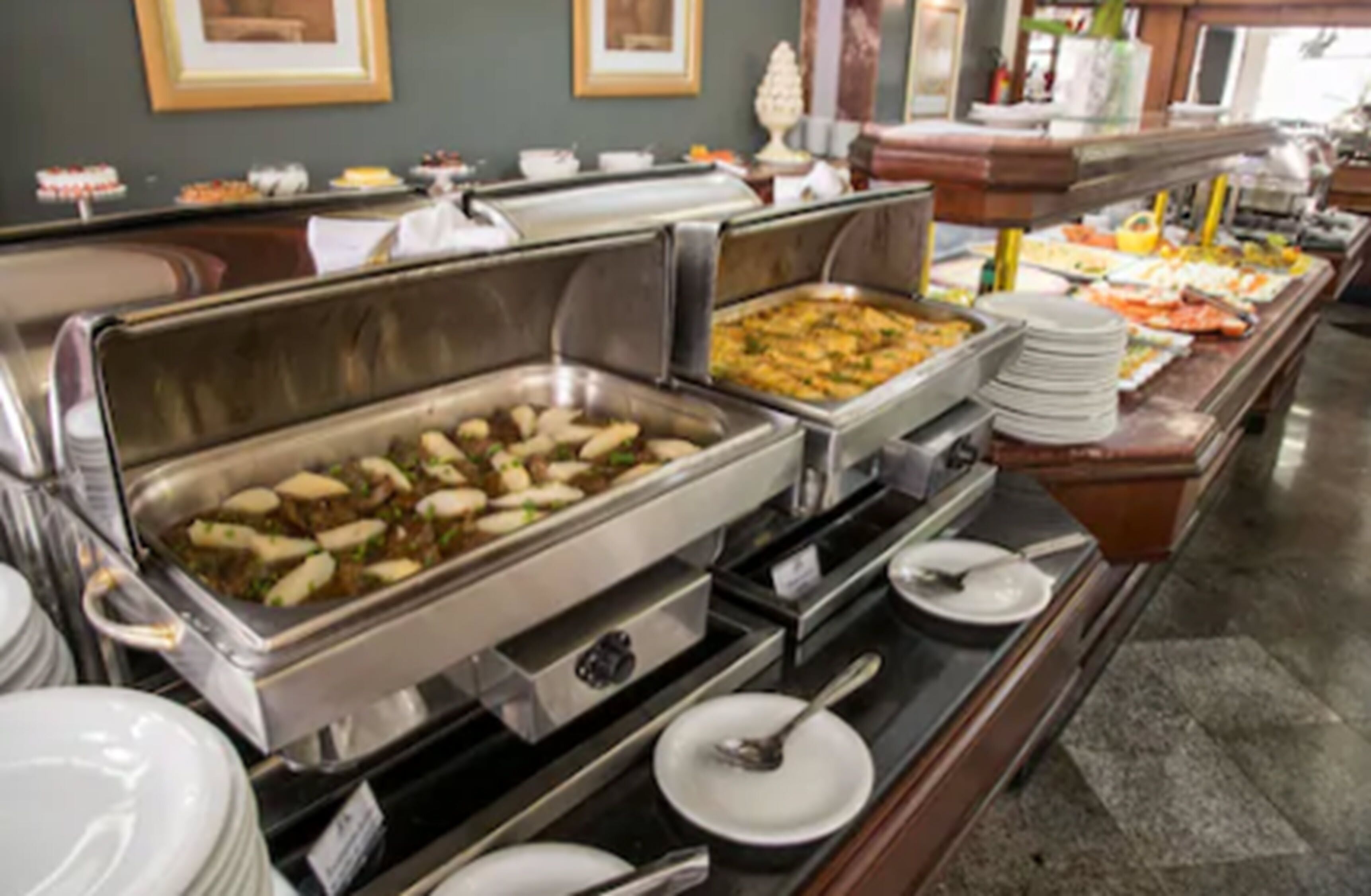 A buffet with various food items and serving utensils.