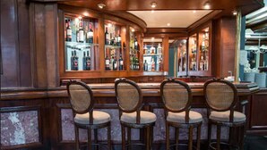 A bar area with wooden bar counters and wicker chairs. - Carlton Plaza Poços de Caldas (Poços de Caldas)