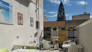 An outdoor patio with tables and chairs, a decorative fence, and a view of the sky. - Bed and breakfast delle palme (Trapani)