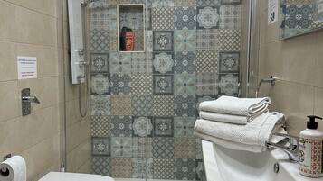 Un baño con ducha, inodoro, bidé y lavabo.