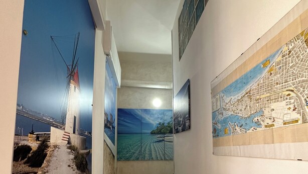 A hallway with tiled walls, a map mural, and a windmill painting. - Bed and breakfast delle palme (Trapani)