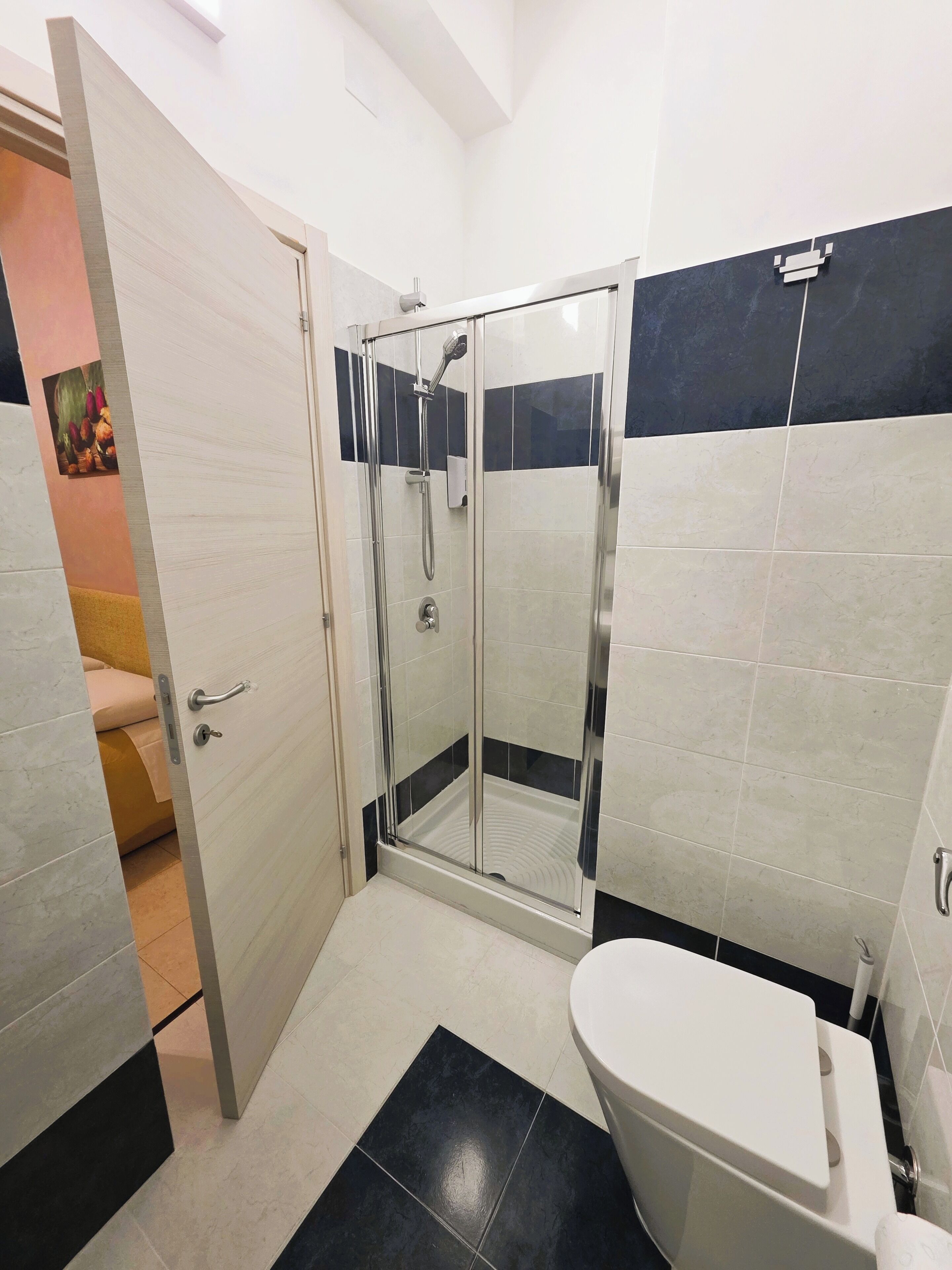 Un baño moderno con ducha de vidrio, inodoro y lavabo.
