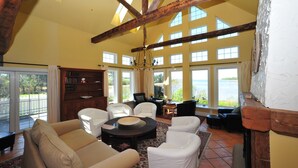 Un salón amplio con techo alto, ventanas grandes y una chimenea.