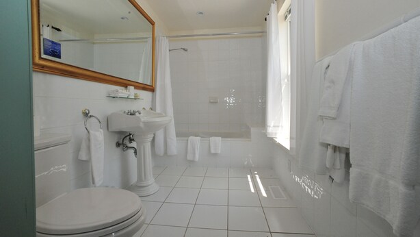 Un baño moderno con inodoro, lavamanos y ducha.