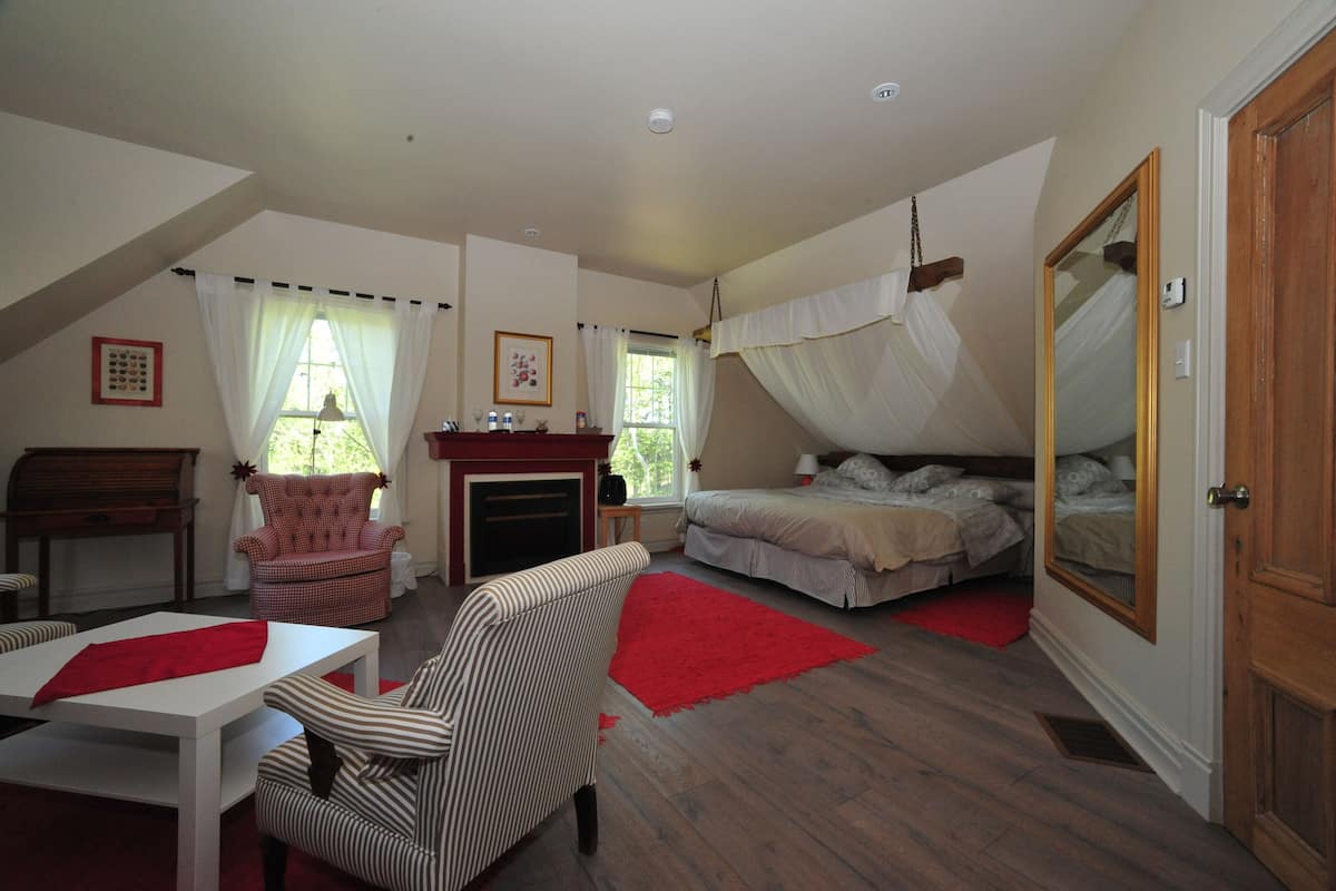 Un dormitorio con una cama, una silla, una mesa y un piano.