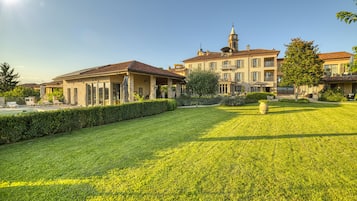 Un'ampia tenuta ben curata con un prato spazioso, una torre imponente e diversi edifici con balconi.